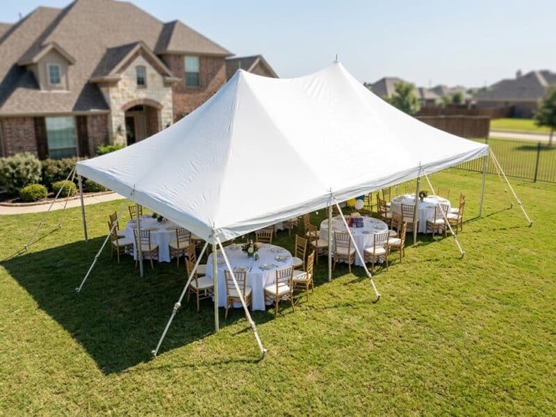 Aerial view of a 20x30 high peak pole tent rental in Burleson TX with gold Chiavari chairs and round tables set for an outdoor backyard event
