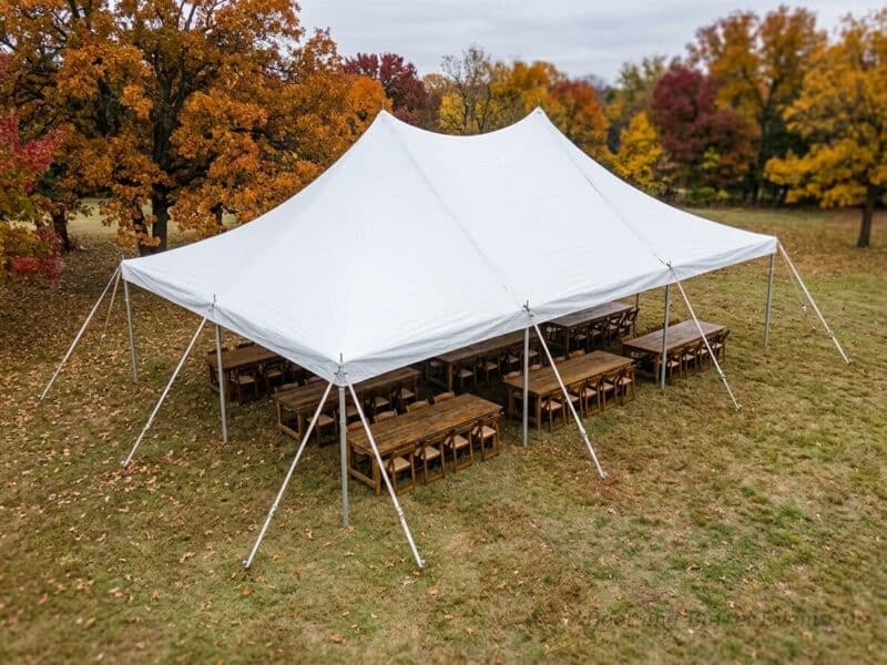 Aerial view of a 20x30 high peak pole tent rental in Alvarado TX with farm tables and cross-back chairs set for a fall outdoor event