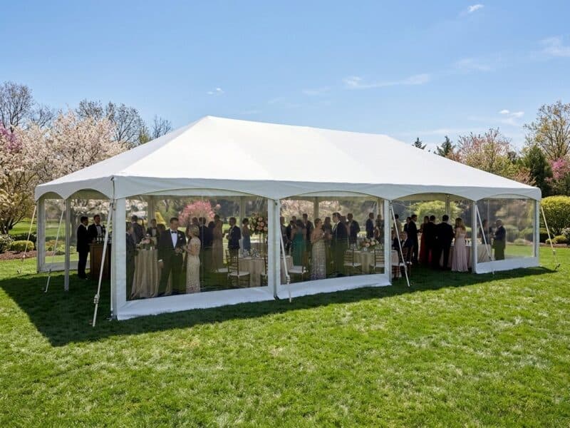 20x40 premium frame tent rental in Cleburne TX with clear sidewalls and wedding guests visible inside on a spring afternoon