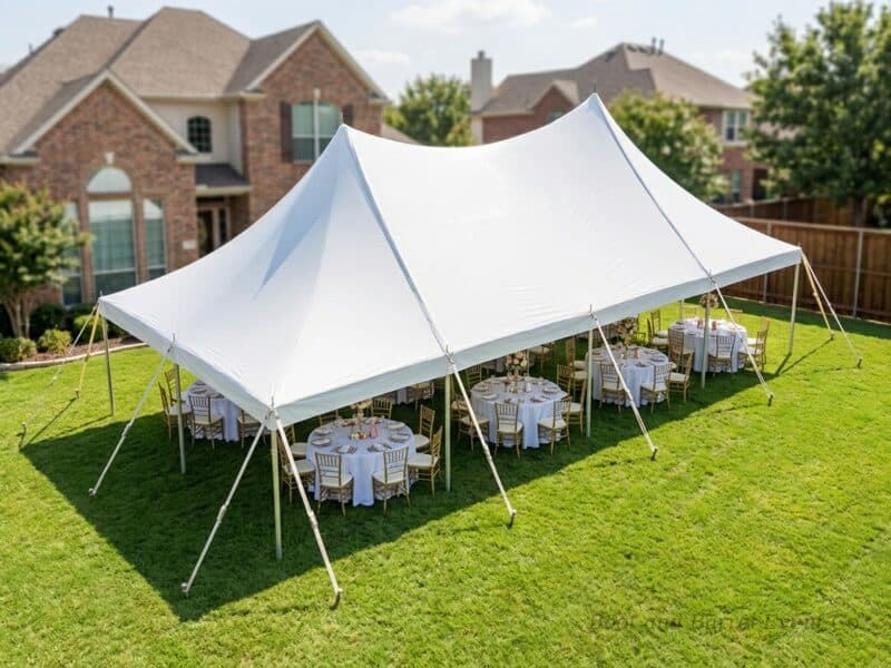 Aerial view of a 20x40 high peak pole tent rental in Joshua TX with gold Chiavari chairs and round tables set for an outdoor backyard reception
