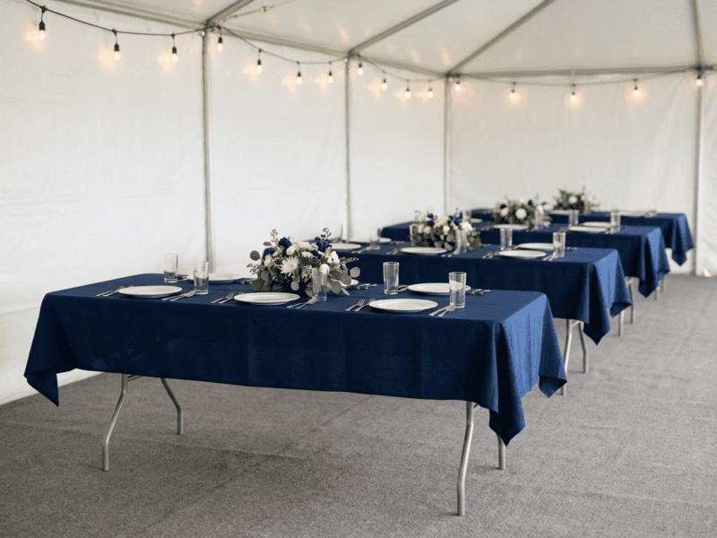 8 foot x 30 inch birchwood banquet table with navy linen for corporate event under tent in Keene Texas