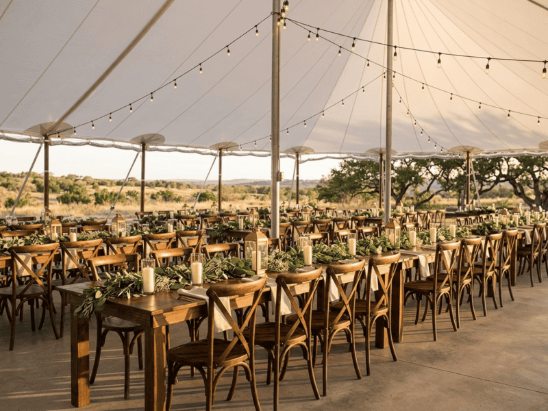 Fruitwood cross-back chair at wedding reception under tent in Cleburne TX — Boot & Barrel Event Co. rental