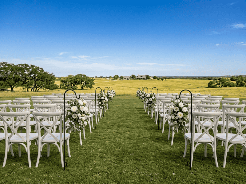 Distressed white cross-back chair at ceremony seating on Texas ranch — Boot & Barrel Event Co. rental
