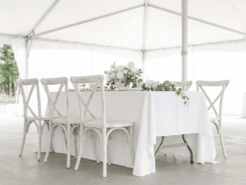 Distressed white cross-back chair paired with linen banquet table in Venus TX — Boot & Barrel Event Co. rental