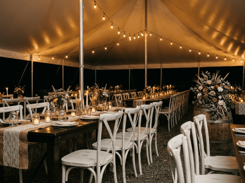 Distressed white cross-back chair at night reception under tent in Burleson TX — Boot & Barrel Event Co. rental