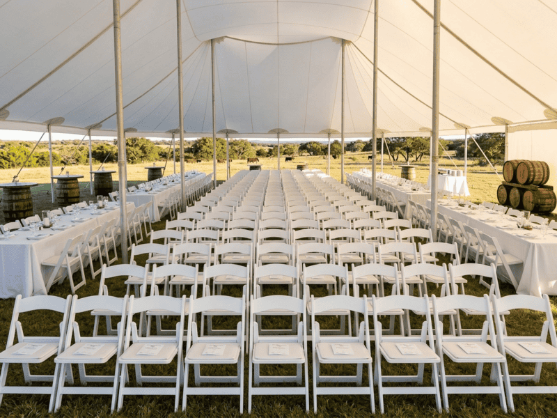White folding chair at corporate event under tent in Cleburne TX — Boot & Barrel Event Co. rental