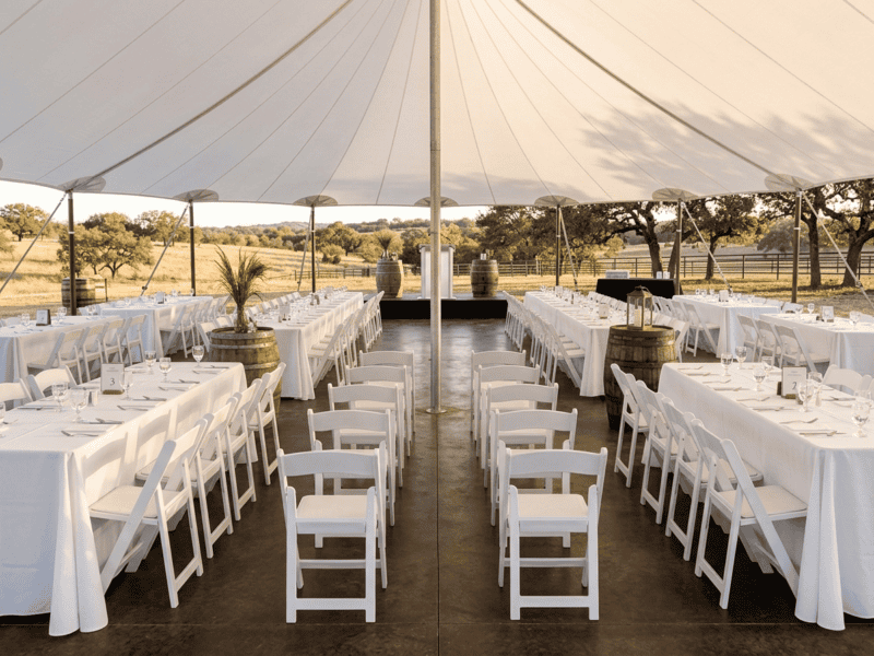 White folding chair at corporate event under tent in Whitney TX — Boot & Barrel Event Co. rental
