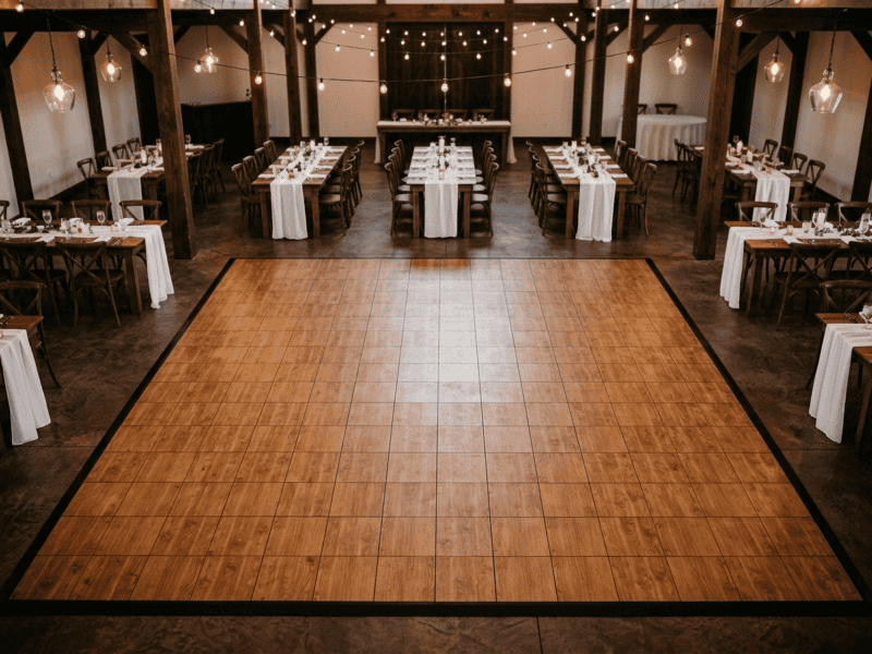 English chestnut indoor dance floor rental at an elegant wedding venue with fruitwood farm tables and string lights — Boot & Barrel Event Co. Rio Vista TX