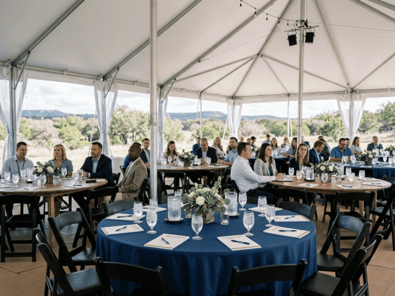 Banquet tables arranged for corporate conference event under tent in Texas