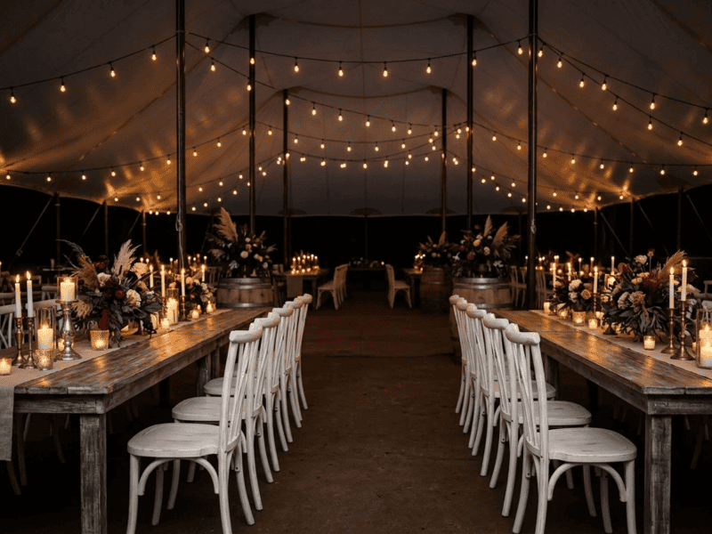 Distressed white willow chair at night reception under tent in Grandview TX — Boot & Barrel Event Co. rental